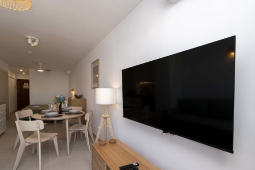 Modern studio apartment in Costa Adeje with wall-mounted TV, dining area, and contemporary furnishings