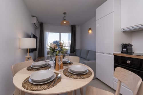 Modern studio apartment in Costa Adeje with dining area, kitchen, sea view balcony, and contemporary furnishings