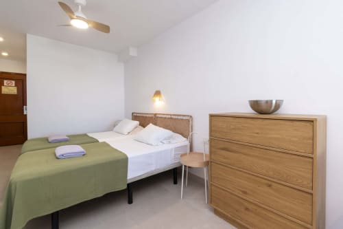 Modern studio bedroom at Marigold in Costa Adeje with twin beds, wooden dresser, ceiling fan, and pendant lighting