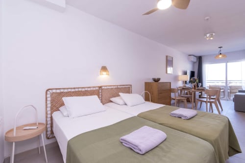 Modern studio apartment in Costa Adeje, Tenerife with sea view, featuring double bed, wooden furnishings, and balcony access