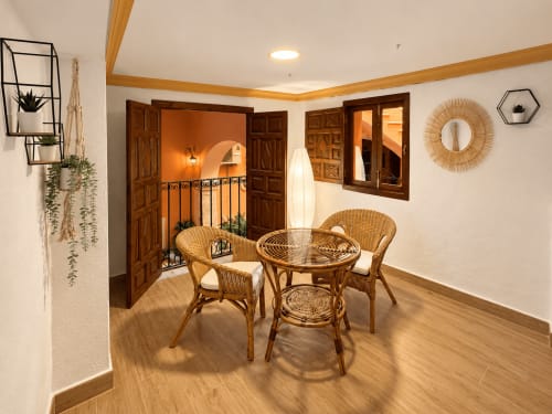 Comedor rústico con sillas de mimbre y mesa redonda en Casa Rural Garden Suites, Xàtiva, España