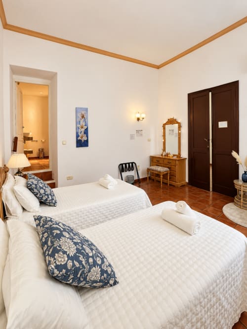 Espacioso dormitorio doble en Casa Rural Garden Suites de Xàtiva con camas individuales, mobiliario de madera y puertas oscuras