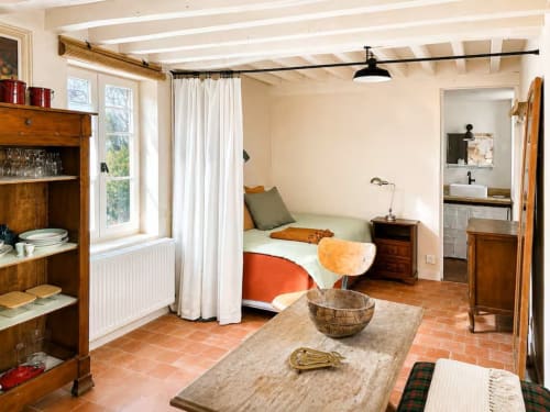 Appartement de Cynthia Balma aux Maraîchades : lit à baldaquin, meubles en bois et vue sur le jardin