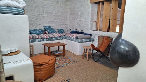 Furanelle B&B Saint Étienne : chambre rustique avec literie rayée, sièges en cuir, ballon de fitness et mobilier en bois