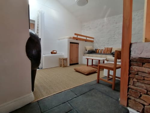 Chambre du gîte Furanelle à Saint Etienne avec lit en bois, tons terre et décoration minimaliste
