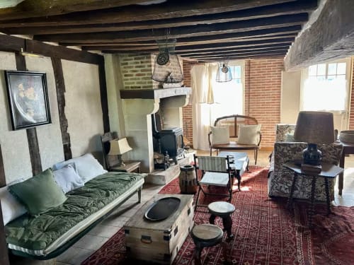 Intérieur rustique du cottage Les Maraîchades avec poutres apparentes, cheminée et mobilier d'époque en Sologne
