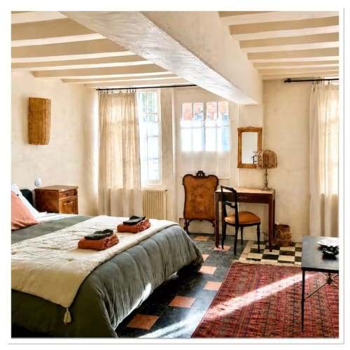 Chambre spacieuse avec poutres apparentes, mobilier en bois et vue sur le jardin du gîte Les Maraîchades en Sologne
