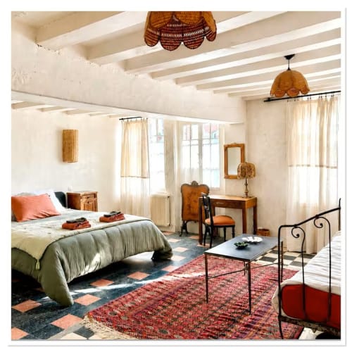 Spacieuse chambre du gîte Les Maraîchades en Sologne avec poutres apparentes, lits multiples, accents en terre cuite et jardin