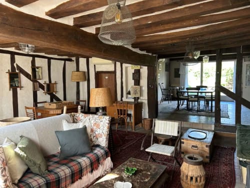 Charmant salon de cottage avec poutres en bois, mobilier d'époque et vue sur le jardin aux Maraîchades, Sologne.