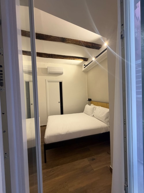 Camera moderna al Salotto Toledo, luxury B&B di Napoli, con travi a vista, biancheria bianca e vista sulla città