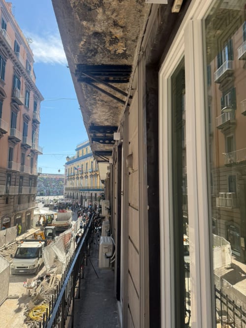 Vista dal balcone dell'hotel Salotto Toledo: strada di Napoli con edifici storici e architettura colorata