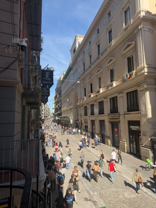 Affollata via pedonale a Napoli con eleganti edifici storici, vista dalle suite lussuose Salotto Toledo