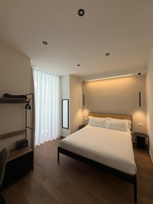 Camera d'hotel di lusso moderno con letto queen, illuminazione ambientale calda, letto a castello e vista sulla città presso Salotto Toledo Naples
