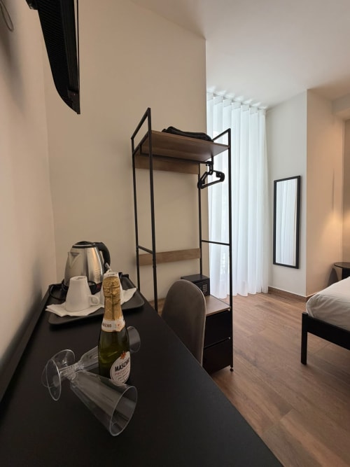 Camera moderna dell'hotel Salotto Toledo a Napoli con letto a castello, bottiglia di champagne e vista sulla città