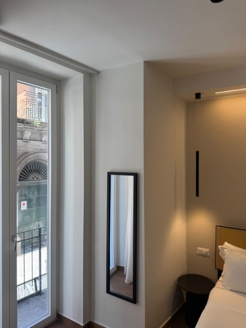 Camera moderna del Salotto Toledo Napoli con balcone vista città, specchio e letto con comfort