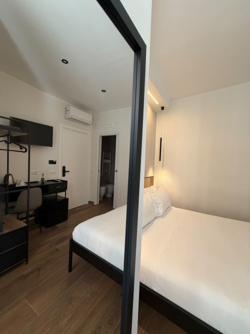 Camera moderna con letto a quattro colonne nel lussuoso BnB Salotto Toledo di Napoli, arredamento nero e design contemporaneo
