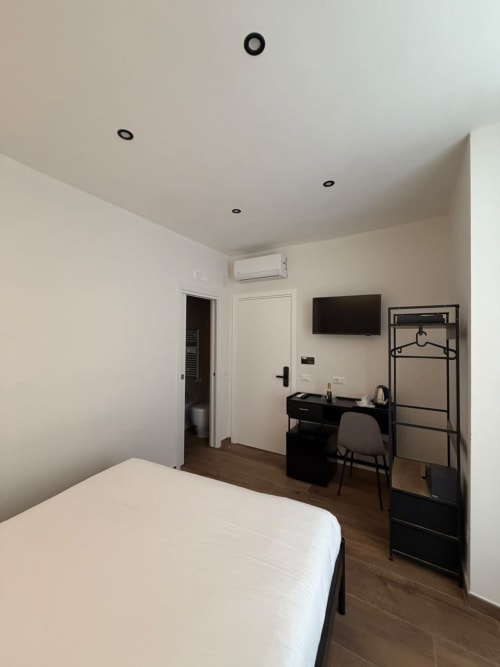 Camera moderna presso Salotto Toledo, lussuoso B&B a Napoli, con letto, scrivania, TV a schermo piatto e aria condizionata