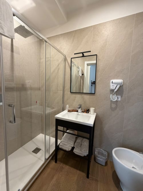 Bagno moderno del lussuoso B&B Salotto Toledo a Napoli con doccia effetto pioggia, lavabo sospeso e vasca rotonda