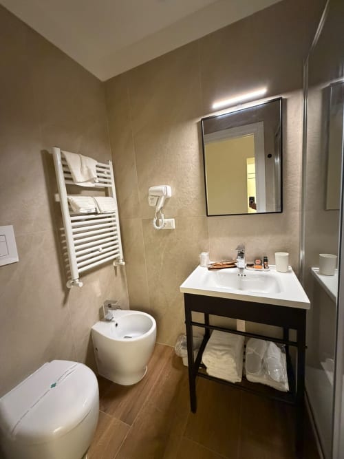 Bagno moderno al B&B di lusso Salotto Toledo a Napoli con lavabo bianco, scaldasalviette e doccia