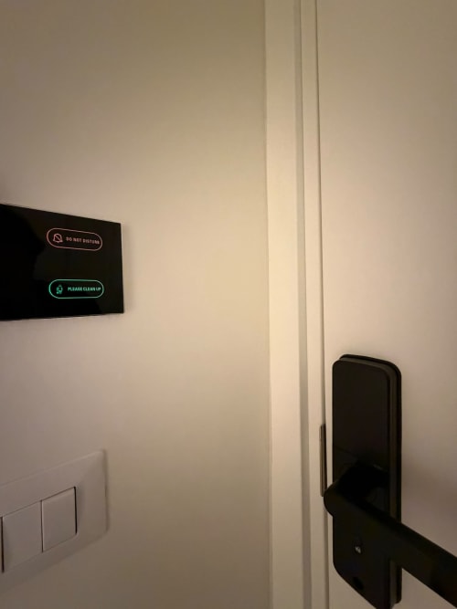 Porta della camera d'albergo con display digitale che mostra i messaggi "Non disturbare" e "Si prega di pulire" al Salotto Toledo Naples