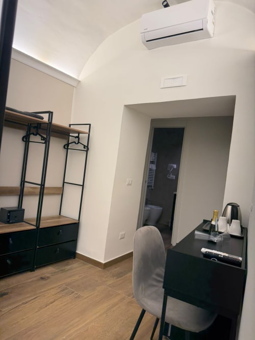 Camera moderna nel lussuoso B&B di Napoli con scrivania, scaffali, aria condizionata, pavimenti in legno e arredamento contemporaneo