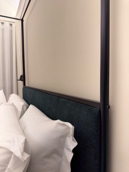 Letto a baldacchino moderno con struttura nera e biancheria bianca presso Salotto Toledo luxury B&B a Napoli, pareti color crema
