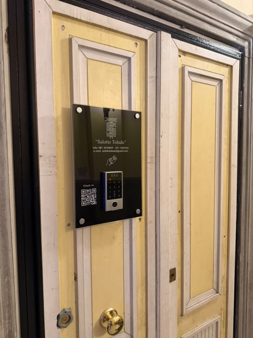 Porta gialla in legno con tastiera digitale al Salotto Toledo, lussuoso B&B a Napoli, Italia