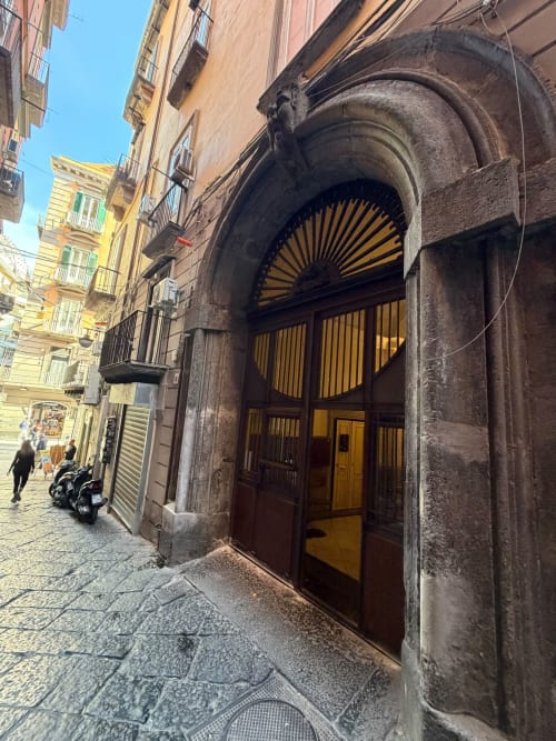 Storico ingresso ad arco delle lussuose camere Salotto Toledo a Napoli, Italia, su un'affascinante via lastricata