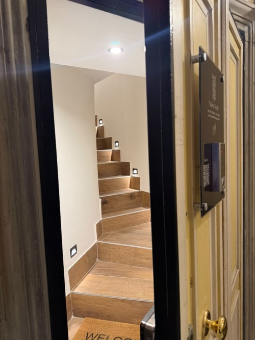 Scala moderna con gradini in legno e illuminazione integrata al Salotto Toledo, lussuoso B&B di Napoli