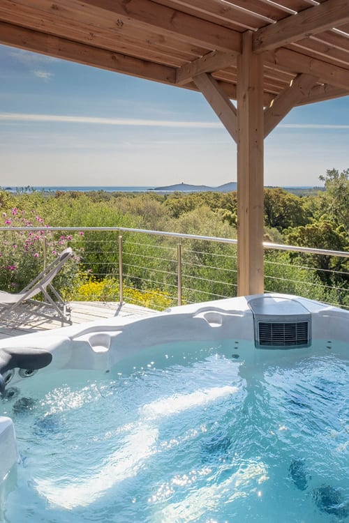 Luxueux jacuzzi sur terrasse en bois surplombant le paysage corse et les montagnes aux Villas d'A Storia