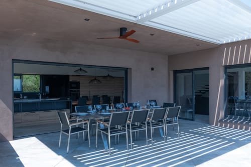 Élégant espace de repas extérieur à la Villa Poggioli à Zonza avec table, chaises et cuisine ouverte