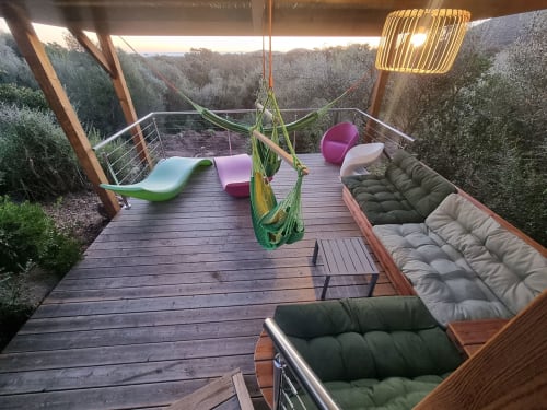 Terrasse de villa de luxe aux Villas d'A Storia avec salon, hamac et vue forestière au coucher de soleil