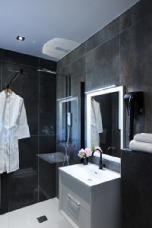 Salle de bain moderne à Villa Poggioli, Les Villas d'A Storia à Zonza avec carrelage noir, lavabo blanc, miroir illuminé et