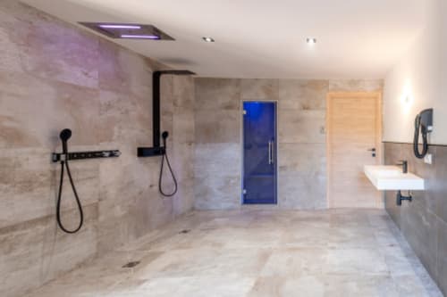 Salle de bain de luxe moderne à la Villa Poggioli avec revêtement en marbre, douche à l'italienne, porte en verre bleu et pluie de tête
