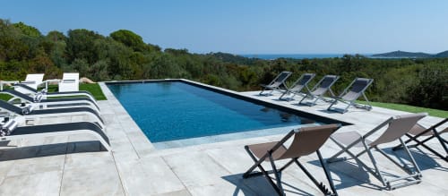 Élégante piscine des Villas d'A Storia à Zonza avec transats, vue mer et paysage méditerranéen