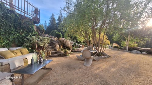 Salon de jardin Furanelle avec sièges modernes, éléments en pierre et grands arbres à Saint Etienne