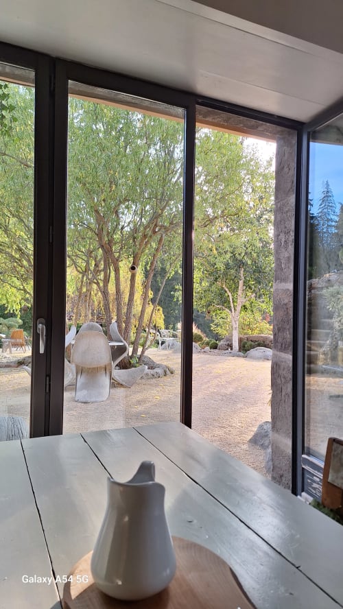 Terrasse du Furanelle B&B à Saint-Etienne avec grandes baies vitrées donnant sur un jardin arborisé et coin détente