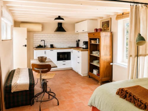 Charmante cuisine et chambre de cottage aux Maraîchades en Sologne avec mobilier blanc, carrelage en terre cuite et jardin