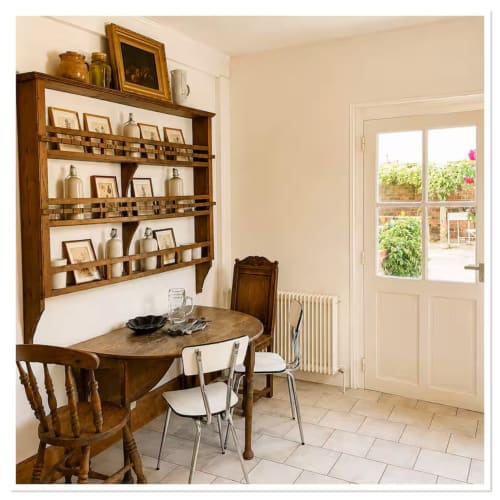 Charmante salle à manger du gîte Les Maraîchades avec vaisselier en bois, table ronde et vue sur le jardin