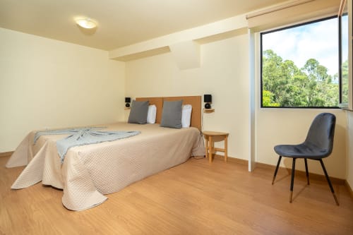 Spacious bedroom in Quinta frizado villa, Prazeres with wooden bed, mountain views, and modern amenities