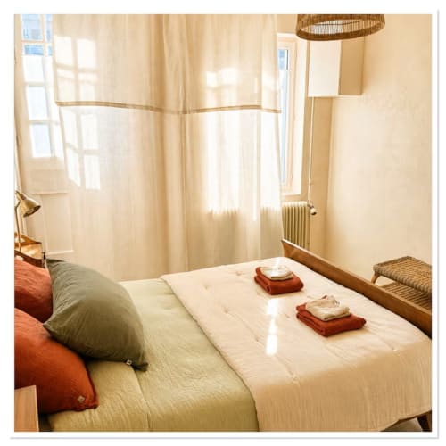 Chambre lumineuse du gîte Les Maraîchades en Sologne avec literie crème, oreiller vert et serviettes préparées