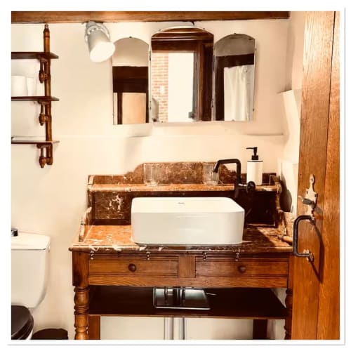 Salle de bain rustique avec meuble vasque en bois, lavabo blanc et miroir au gîte Les Maraîchades en Sologne