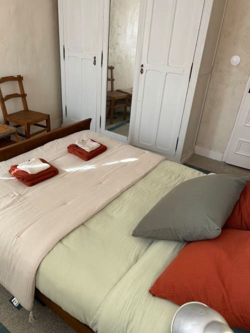 Chambre accueillante du gîte Les Maraîchades en Sologne avec lit aux draps rouges, mobilier en bois et armoire miroir