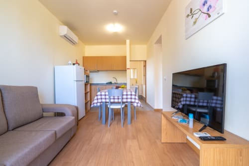Modern villa living room in Prazeres with dining area, kitchenette, flat-screen TV, and comfortable seating with mountain