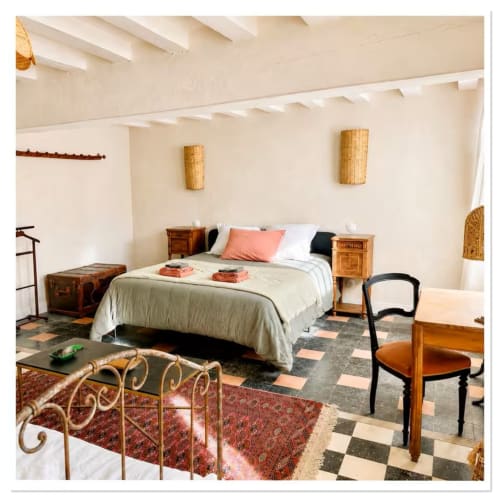 Chambre de charme au gîte Les Maraîchades en Sologne avec poutres apparentes, carrelage en terre cuite et vue sur le jardin