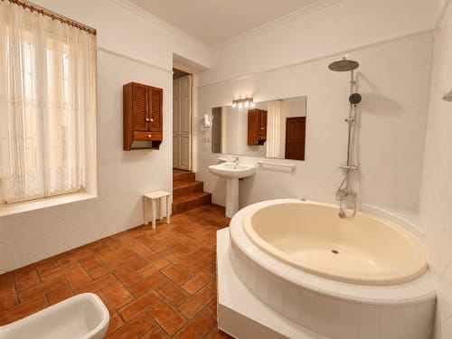 Baño amplio en Casa Rural Garden Suites de Xàtiva con bañera redonda, lavabo pedestal y ducha moderna