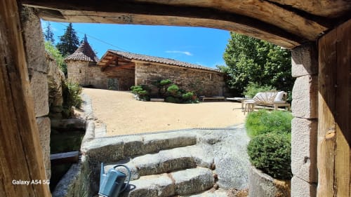 Cour du gîte Furanelle à Saint Etienne : escaliers en pierre, architecture rustique et ciel bleu dégagé