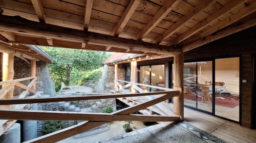 Terrasse couverte du Furanelle BnB avec poutres en bois, murs en pierre et portes coulissantes vitrées, Saint Étienne