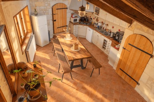 Cuisine et salle à manger ensoleillées du gîte Maison Minérale au Clos Divin, Doué-la-Fontaine, avec table en bois, blanc
