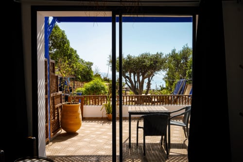 Lazulite room terrace at Imsouane Surf Paradise with ocean view, wooden railings, and coastal landscape in Agadir, Morocco